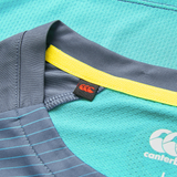 Close-up of the teal Ireland 26/27 Summer Tour Superlight Training Tee by Canterbury, featuring a gray collar, yellow trim, and red Canterbury logo tag.