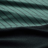 Close-up of green fabric with thin vertical black stripes above a section of solid black fabric, highlighting the texture and folds—typical detailing found on the Ireland 26 Training Tank by Canterbury AW26, designed for performance and comfort by Canterbury.