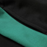 Close-up of black fabric from the Women’s Ireland 26 Legends Fleece Pant by Canterbury, with a green band or stripe running diagonally across the image.