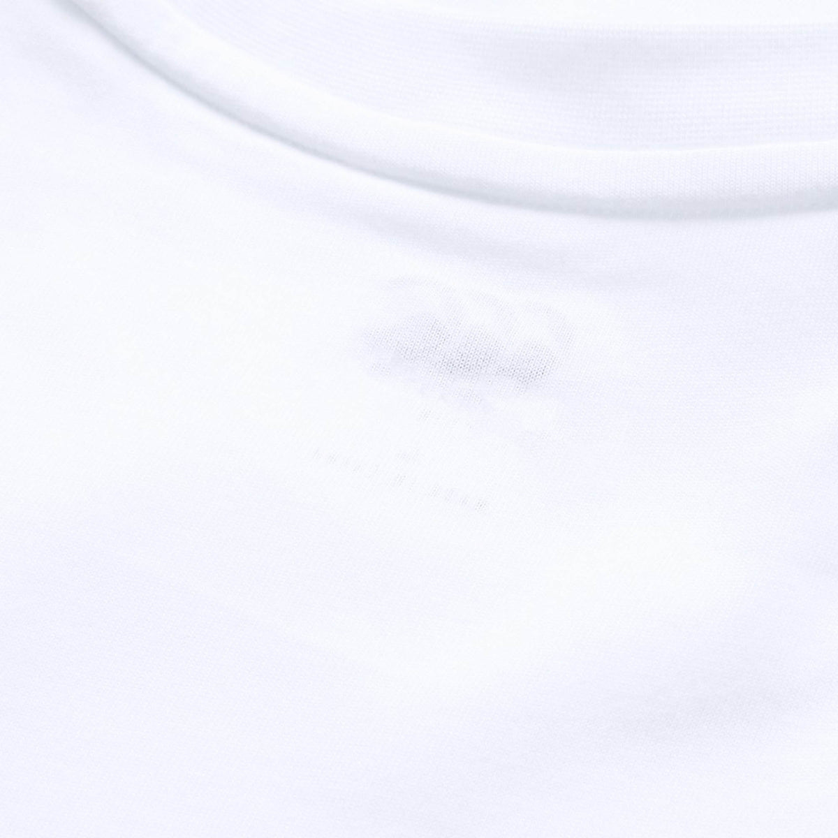 Close-up of the Canterbury Tempo+ GFX Training Tank’s white collar and neckline, featuring a subtle, tagless printed label inside the fabric—ideal for those seeking lightweight workout comfort or dependable Canterbury training wear.