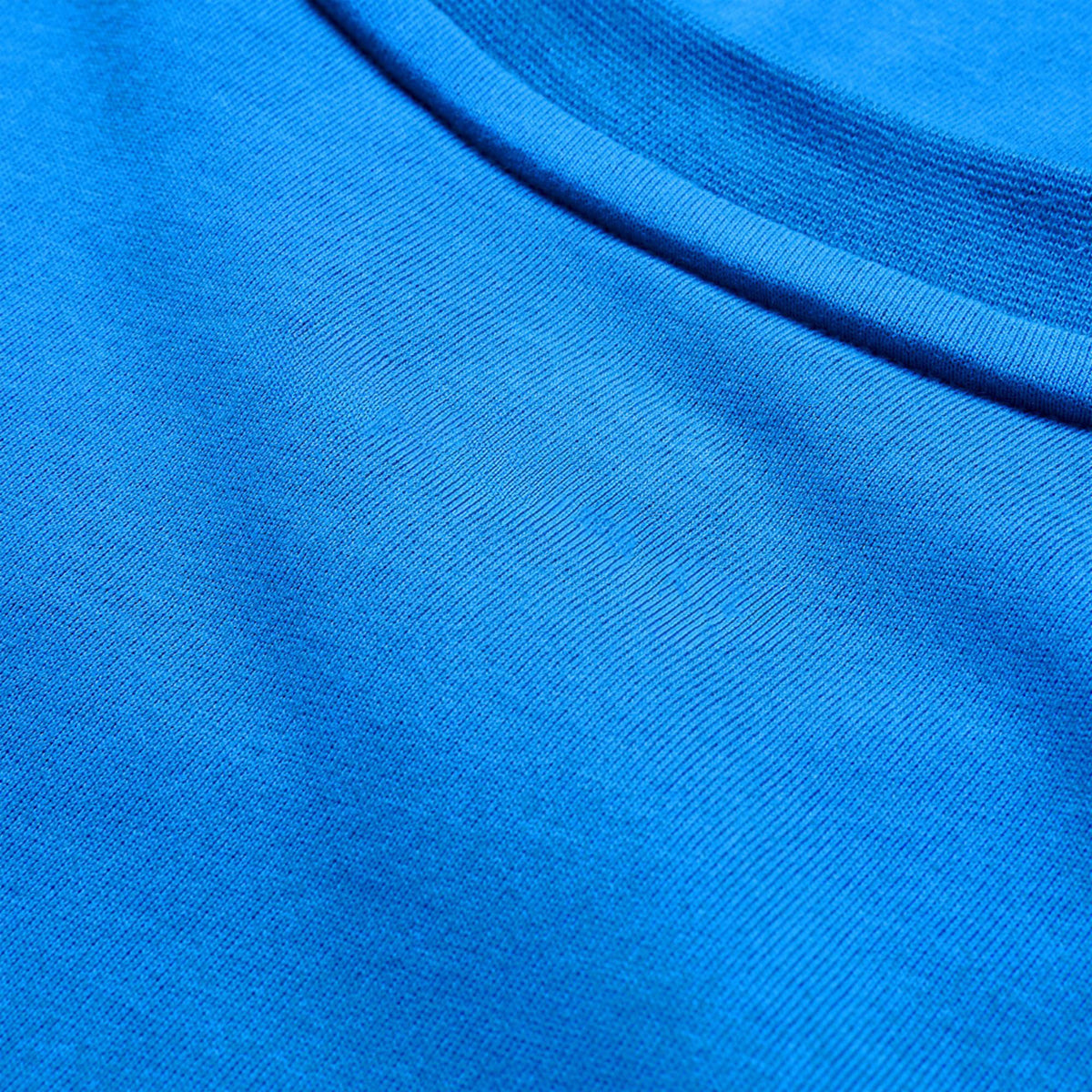 Close-up view of blue fabric with a visible seam, highlighting the texture and weave of the lightweight Canterbury Tempo+ GFX Training Tank by Canterbury—perfect for intensive training sessions.