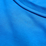 Close-up view of blue fabric with a visible seam, highlighting the texture and weave of the lightweight Canterbury Tempo+ GFX Training Tank by Canterbury—perfect for intensive training sessions.