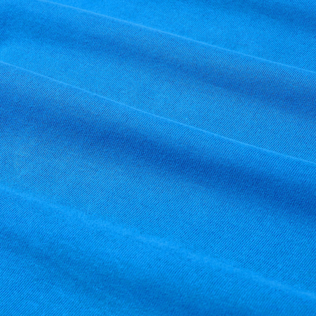 Close-up of blue fabric with horizontal folds and a soft texture, highlighting the premium quality of the Canterbury Tempo+ GFX Training Tank by Canterbury.