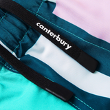 Close-up of the Uglies Harletic Short by Canterbury—a women's rugby training short featuring black drawstrings and a white "canterbury" logo, set against teal, aqua, and light pink color blocks.