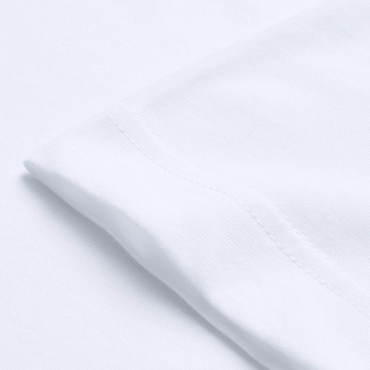 Close-up of the sleeve and seam of a Canterbury Tempo+ GFX Training T-Shirt in plain white, laid flat on a white surface.