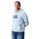 A person wearing a light gray Canterbury Women Rakaia 2.0 Hoodie with a front pocket and logo, paired with blue jeans, stands facing forward against a white background.