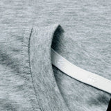 Close-up of the light grey heathered collar on the Canterbury Rakaia 2.0 T-shirt, featuring visible stitching and a white tag partially tucked inside the neckline—a fine example of classic New Zealand rugby apparel from Canterbury.