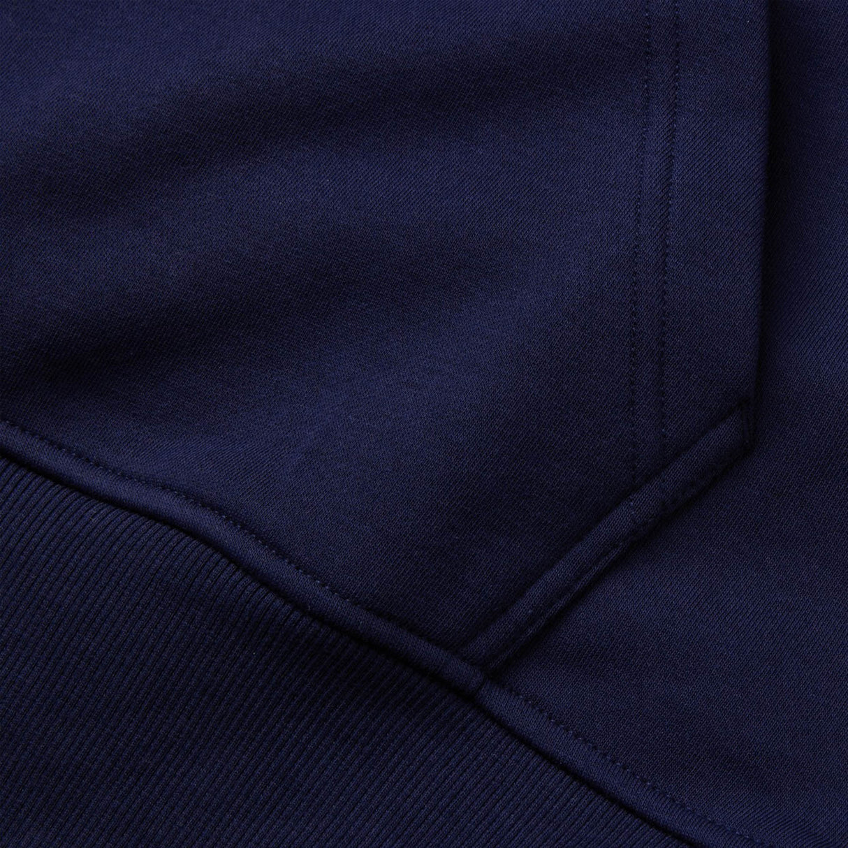 Close-up of the Canterbury Rakaia 2.0 Hoodie in dark blue, featuring visible stitching and seam details characteristic of Canterbury garments.