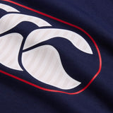 Close-up of the navy blue fabric from the Canterbury Rakaia 2.0 Hoodie by Canterbury, highlighting a white and red logo with curved elements and chevron-like detailing on the white sections.