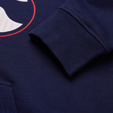 Close-up of a navy blue Canterbury Rakaia 2.0 Hoodie sleeve, showcasing the ribbed cuff and part of a printed red and white graphic.