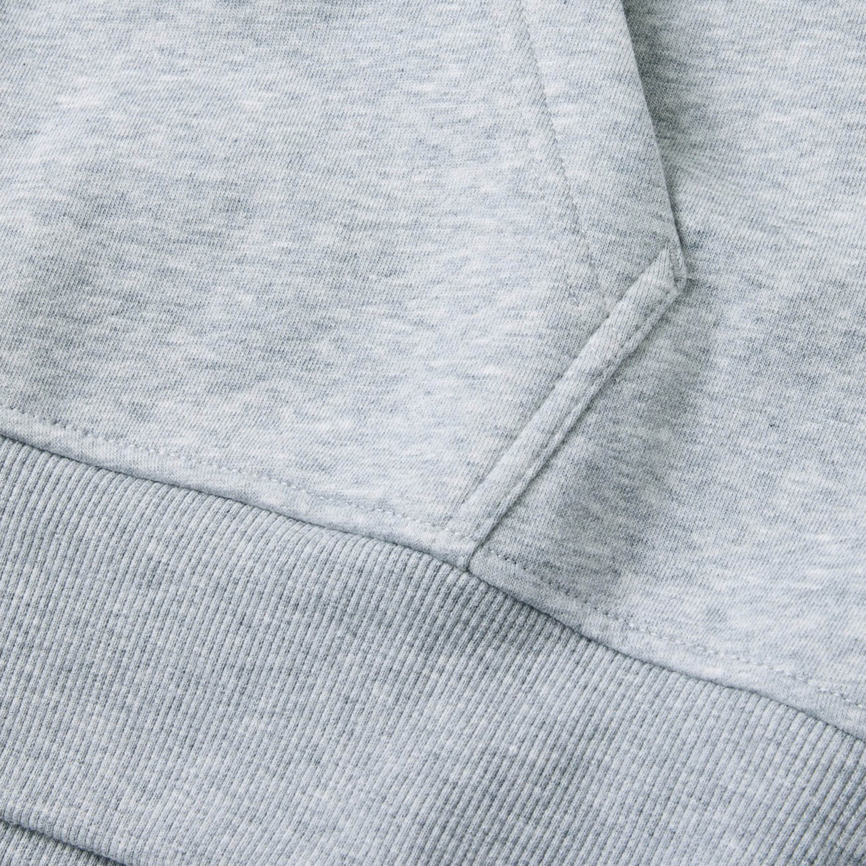 Close-up of the Canterbury Rakaia 2.0 Hoodie fabric in light gray, highlighting the pocket and ribbed waistband detail.