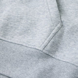 Close-up of the Canterbury Rakaia 2.0 Hoodie fabric in light gray, highlighting the pocket and ribbed waistband detail.