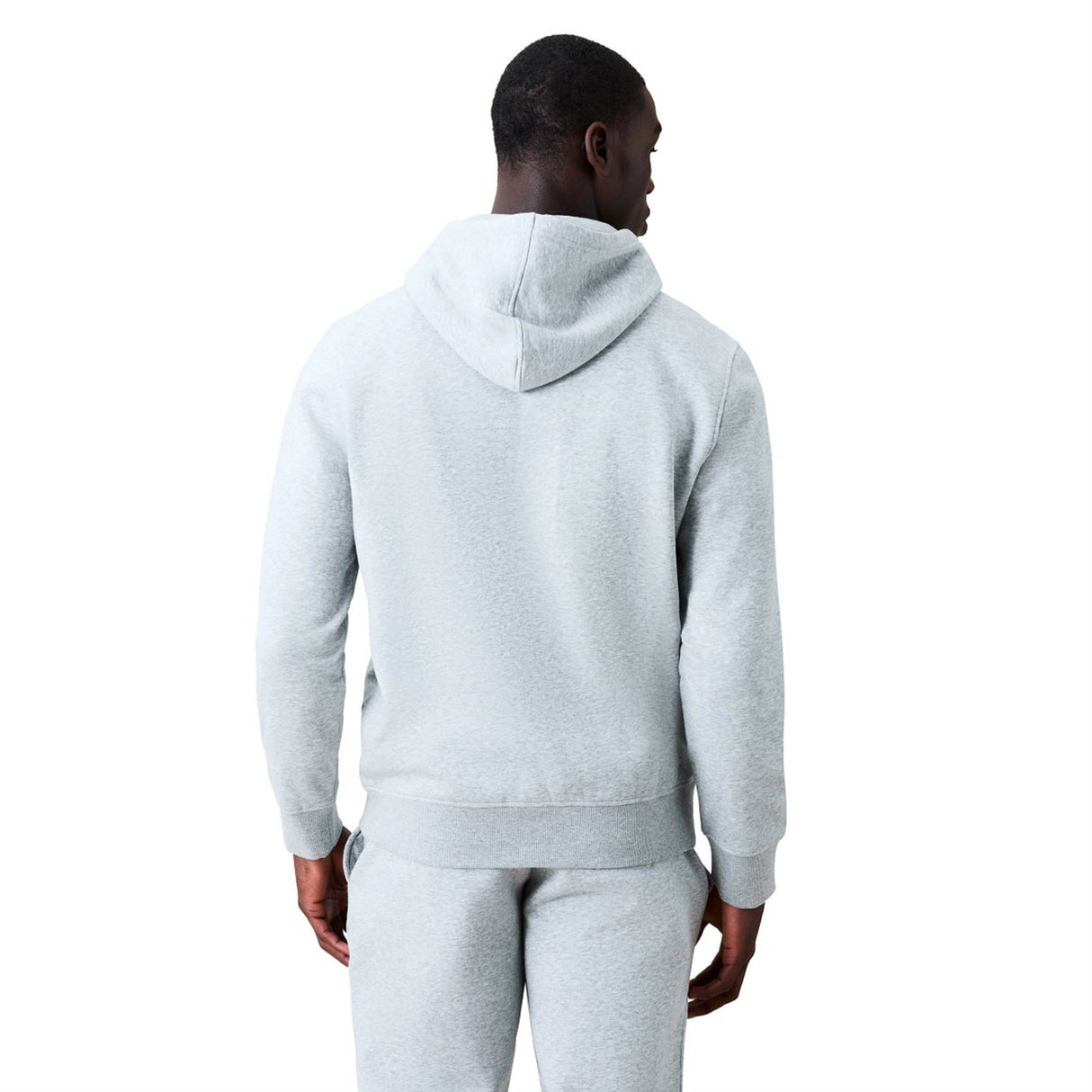 A man stands facing away from the camera, wearing a light gray Canterbury Rakaia 2.0 Hoodie and matching sweatpants against a plain white background.