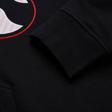 Close-up of a black sweatshirt sleeve with ribbed cuff, with part of a white and red graphic visible on the fabric, highlighting the iconic design details of the Canterbury Rakaia 2.0 Hoodie by Canterbury.