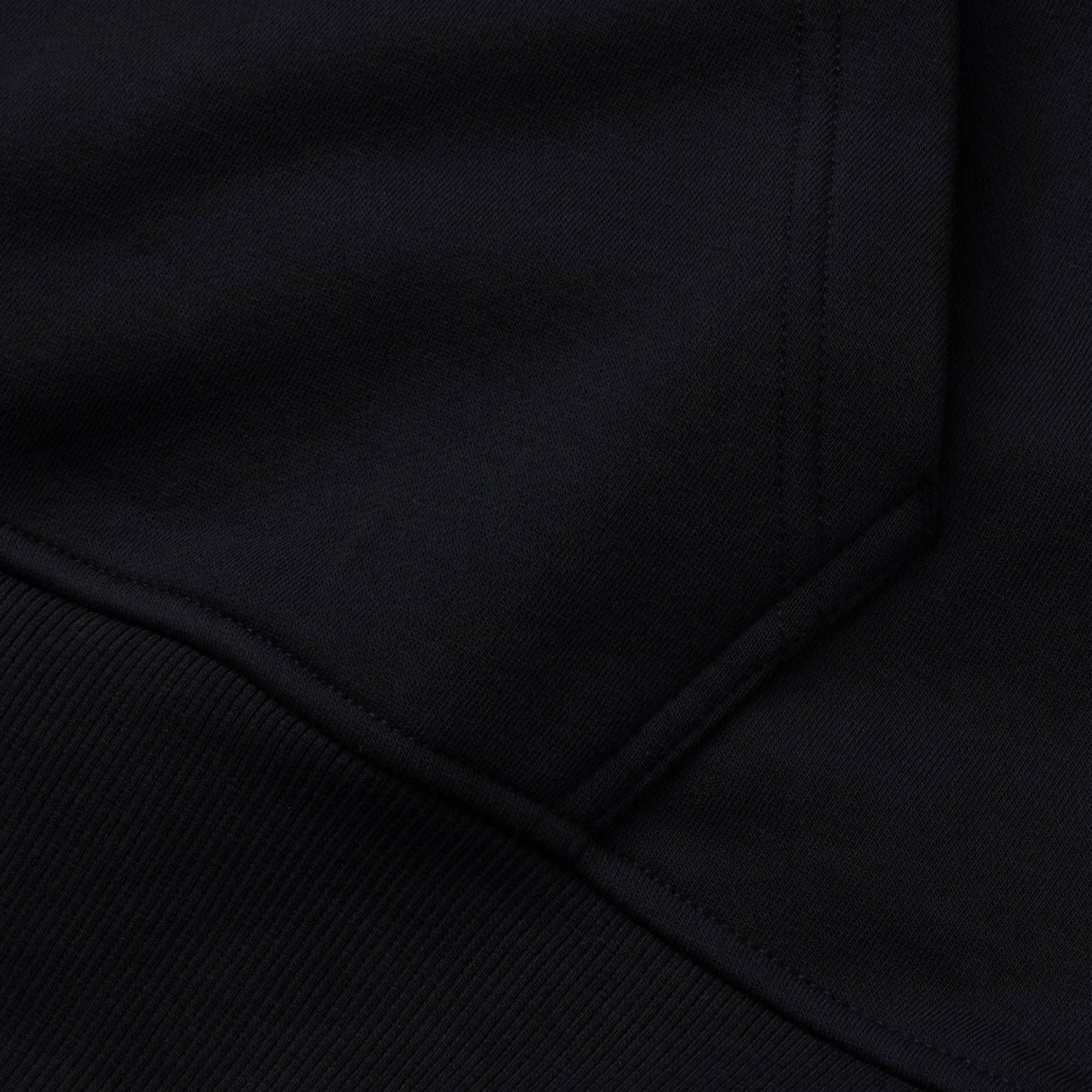 Close-up of the Canterbury Rakaia 2.0 Hoodie in black, highlighting the seam and pocket detail with visible stitching.