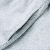 Close-up of the pocket on the light gray Rakaia 2.0 Fleece Pant by Canterbury, featuring visible stitching, a ribbed waistband, and detailed fabric texture.
