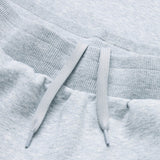Close-up of the waistband and drawstrings on Canterbury's Rakaia 2.0 Fleece Pant for men, featuring a soft, ribbed light gray fabric.