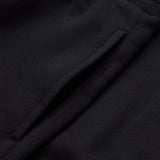 Close-up of a black fabric garment, showing a slanted pocket opening with visible stitching detail, as seen on the Canterbury Rakaia 2.0 Fleece Pant.