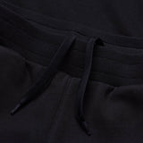 Close-up view of the black waistband featuring a ribbed elastic band and two drawstrings, part of the men's Rakaia 2.0 Fleece Pant by Canterbury.