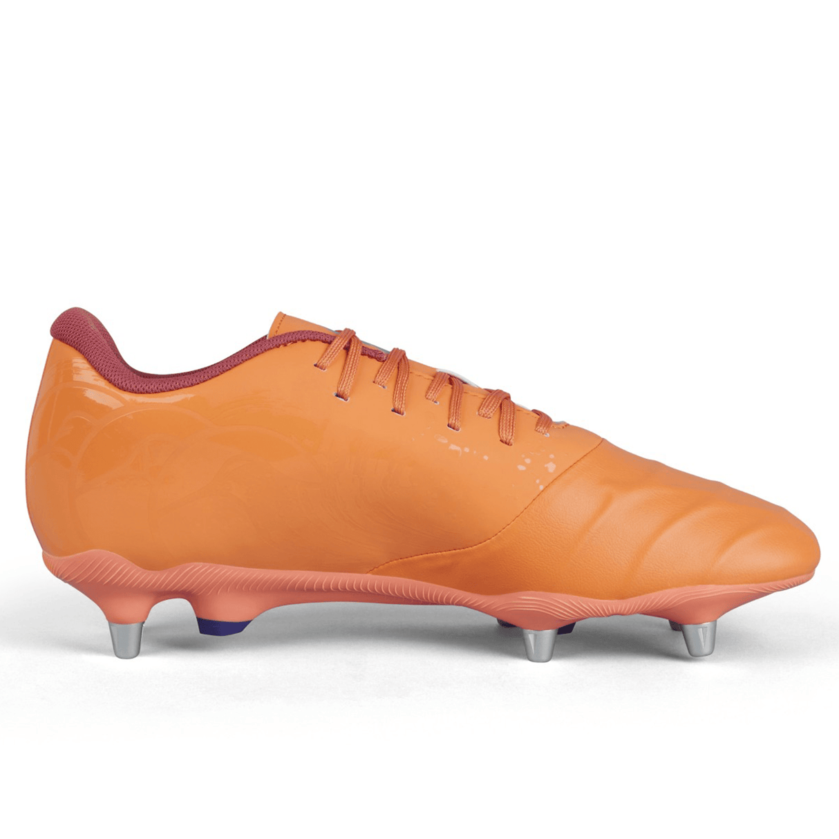 The Canterbury Phoenix Genesis Pro SG in Orange Crush/Amber Yellow/Mars Dust, a standout soft ground boot featuring metallic studs and red laces, is displayed on a plain white background. This cleat promises ultimate traction on the field.
