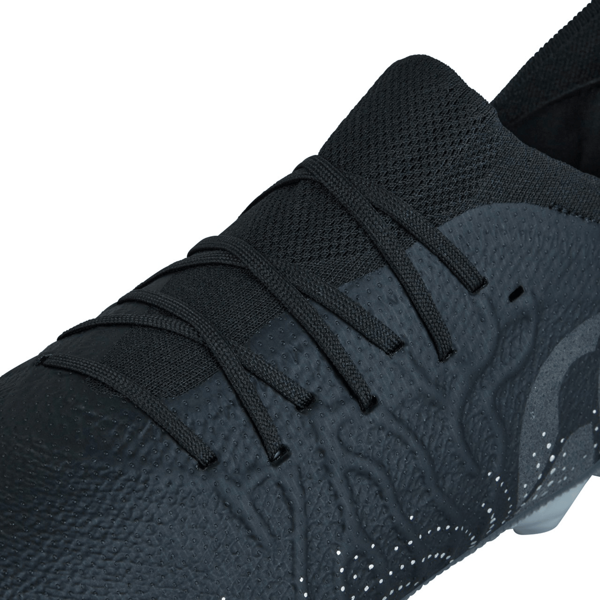 Close-up of the Canterbury Speed Infinite Elite SG - Black/Silver Metallic athletic shoe by Canterbury, showcasing its lace-up design, textured details, and patterned Black/Silver Metallic surface.