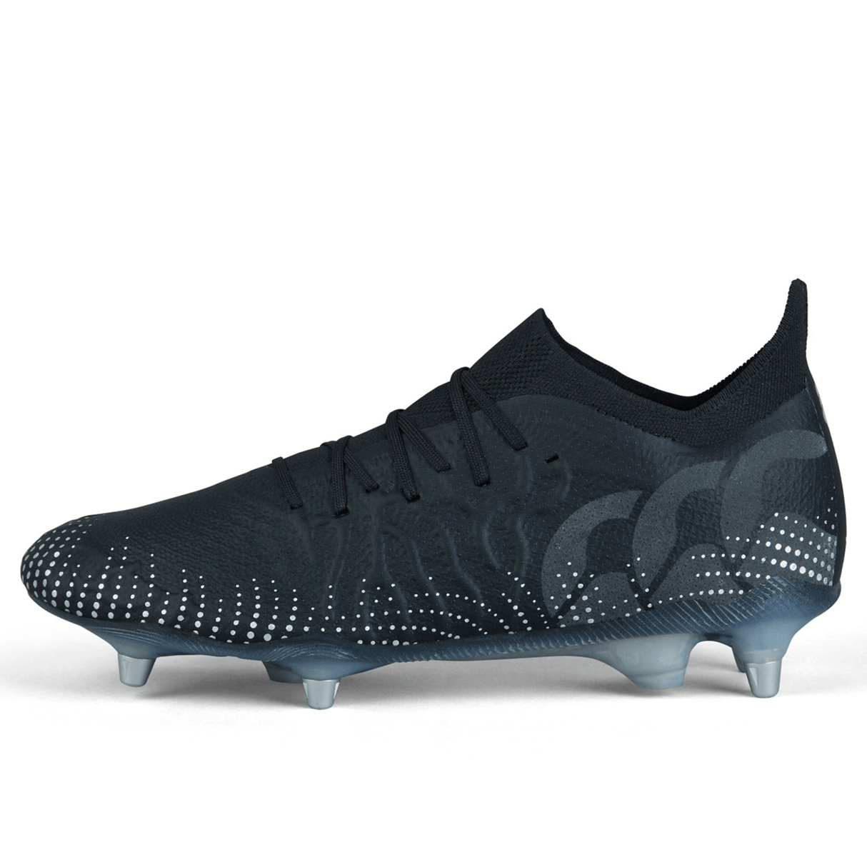 The Canterbury Speed Infinite Elite SG - Black/Silver Metallic, a pair of black soccer cleats with white dots, features studs on the sole for traction. The shoe is designed for athletic performance and is displayed against a plain white background.