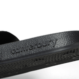 Close-up of the Canterbury Wide Fit Slide - Black, featuring the word "Canterbury" embossed on the side of the sole, designed for all-day comfort.