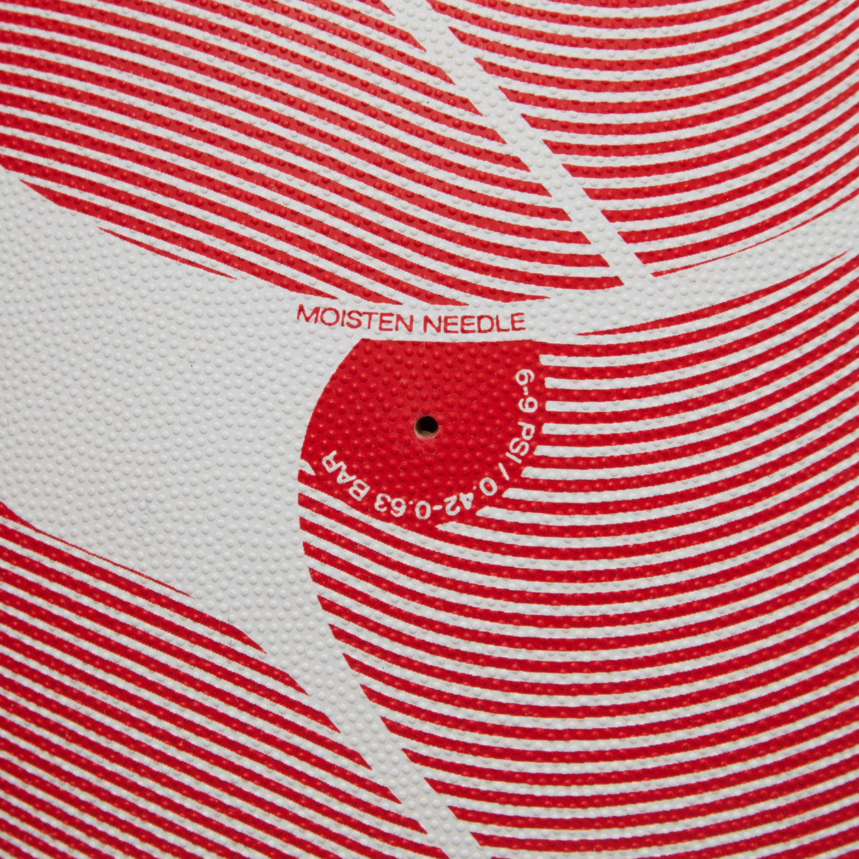 Close-up of a Canterbury Thrillseeker Play Rugby Ball texture with red patterns and instructions to 'moisten needle' before insertion.