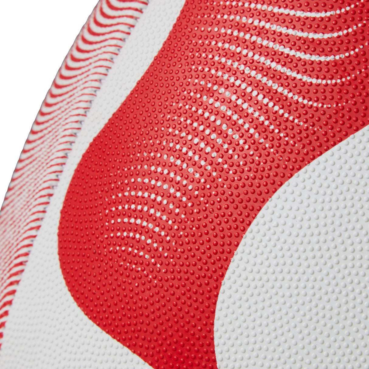 Close-up of a textured Canterbury Thrillseeker Play Rugby Ball with a red and white pattern.