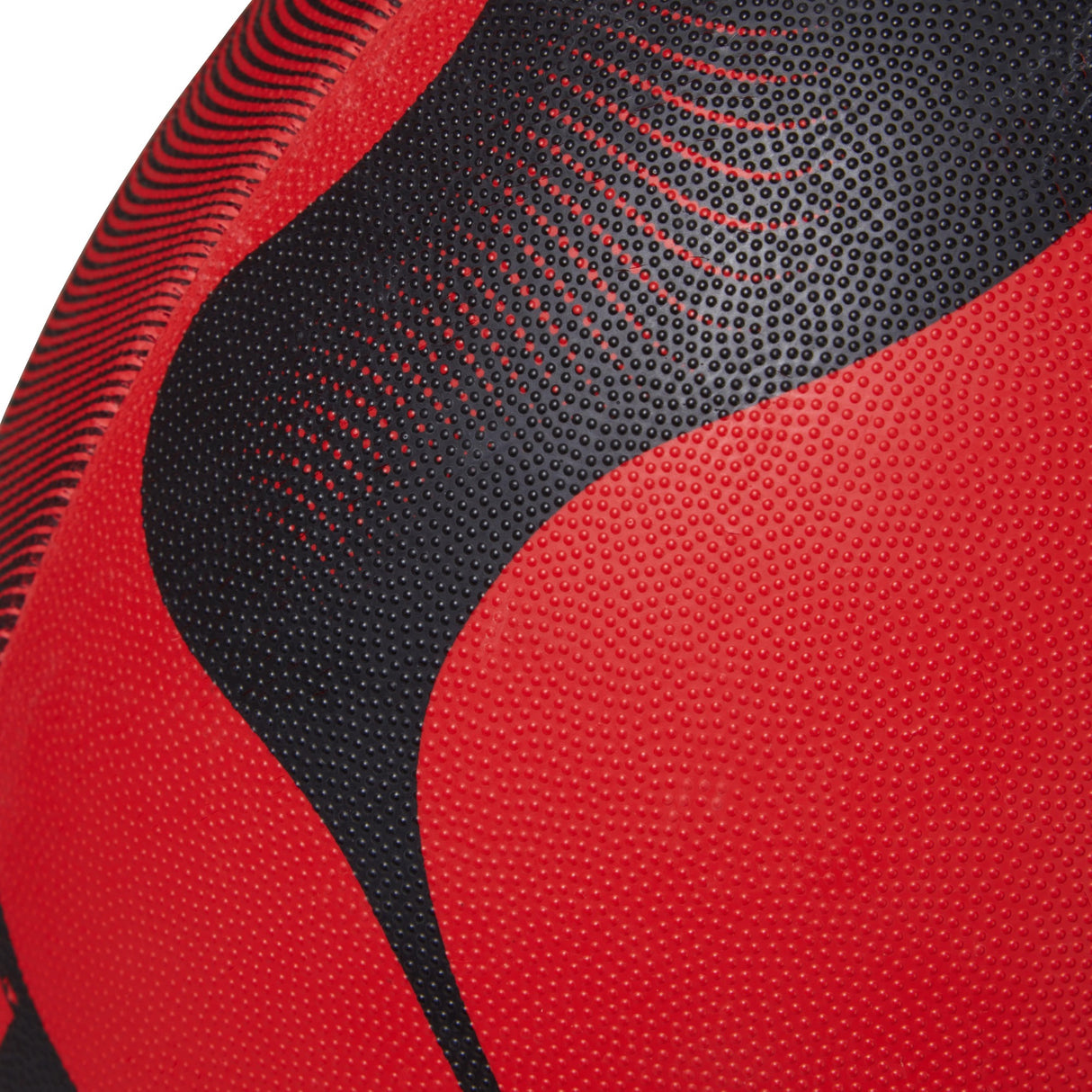 Close-up of a textured red and black Canterbury Thrillseeker Play Rugby Ball surface.