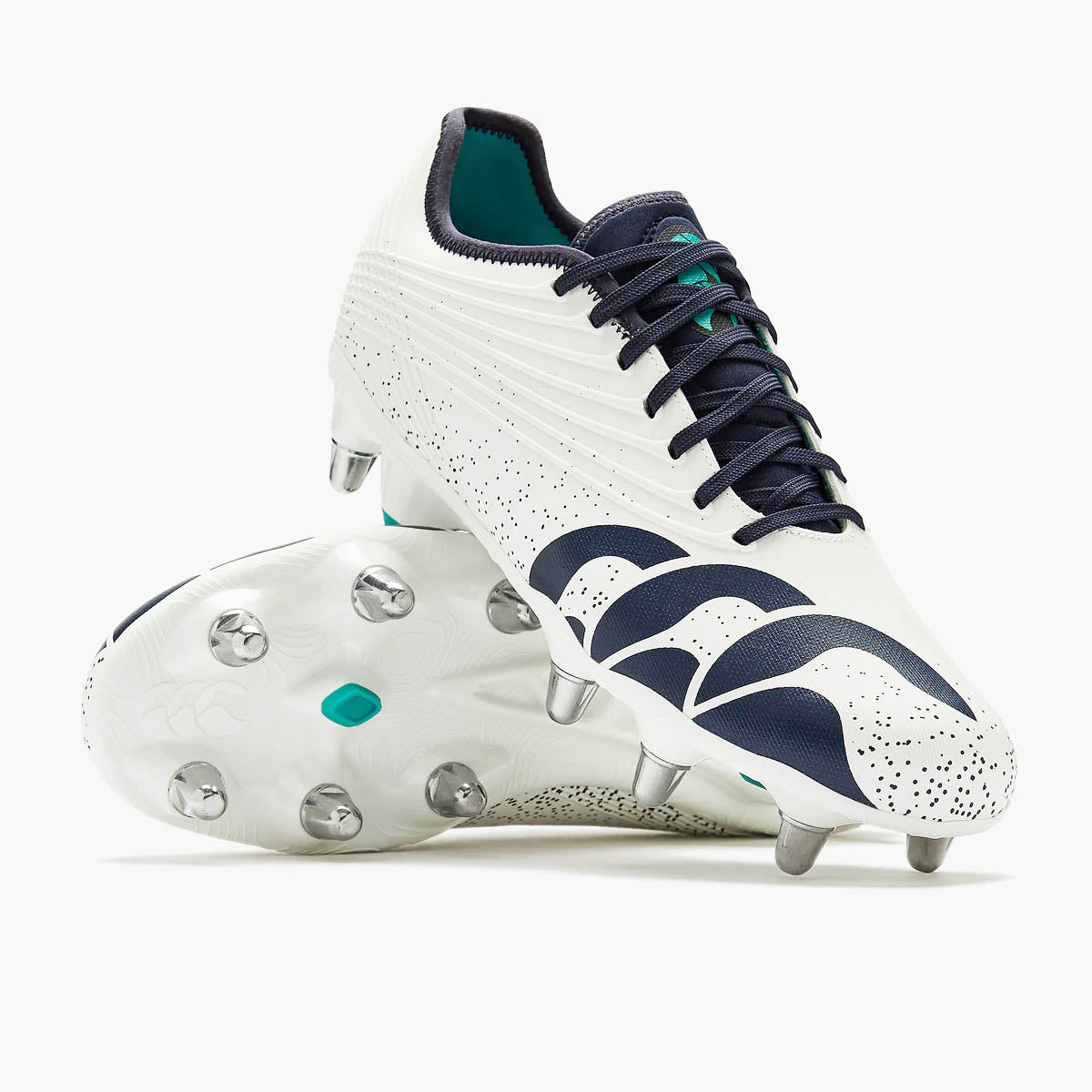The Canterbury Stampede Groundbreak Pro SG AU-WHITE/BALTIC GREEN rugby boots by Canterbury, featuring a white base with Baltic green accents, metal studs, and a speckled design, are displayed on a plain background—these premium soft ground boots deliver the grip and support needed for scrum specialists.