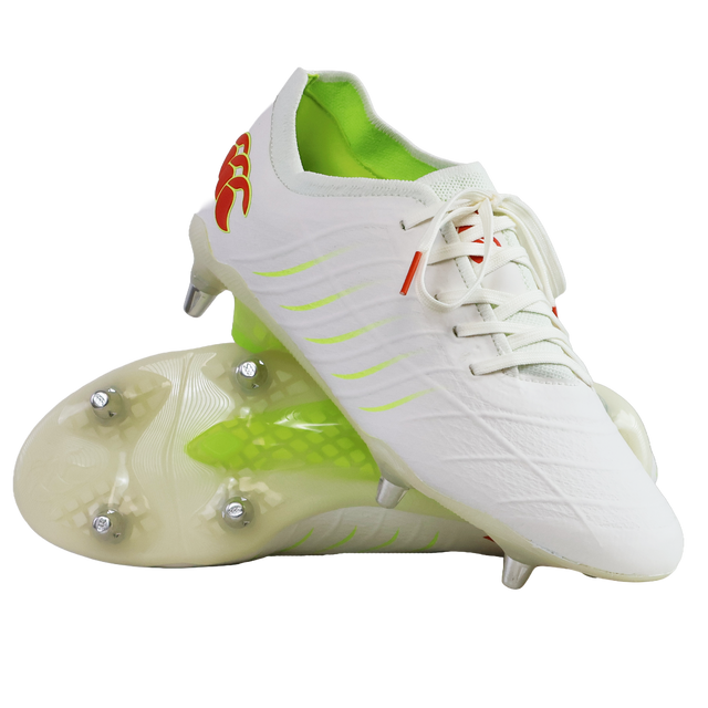 The Canterbury Phoenix 2.0 Elite SG rugby boots in Snow White/Tangerine Tango feature neon green lining, red accents, and metal studs, and are displayed on a plain white background.