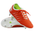 The Canterbury Phoenix 2.0 Pro SG boots in Tangerine Tango/Snow White feature green inner lining; one stands upright, the other lies on its side, displaying metal studs that highlight their durable sports design.