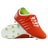 A pair of Canterbury Phoenix 2.0 Pro FG soccer cleats in Tangerine Tango/Snow White, one upright and one sole up to display the green-studded bottom.