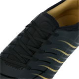 Close-up of the Canterbury Phoenix 2.0 Team FG rugby boot in black, featuring yellow interior lining, black laces, and a wavy yellow design—ideal for firm ground play.