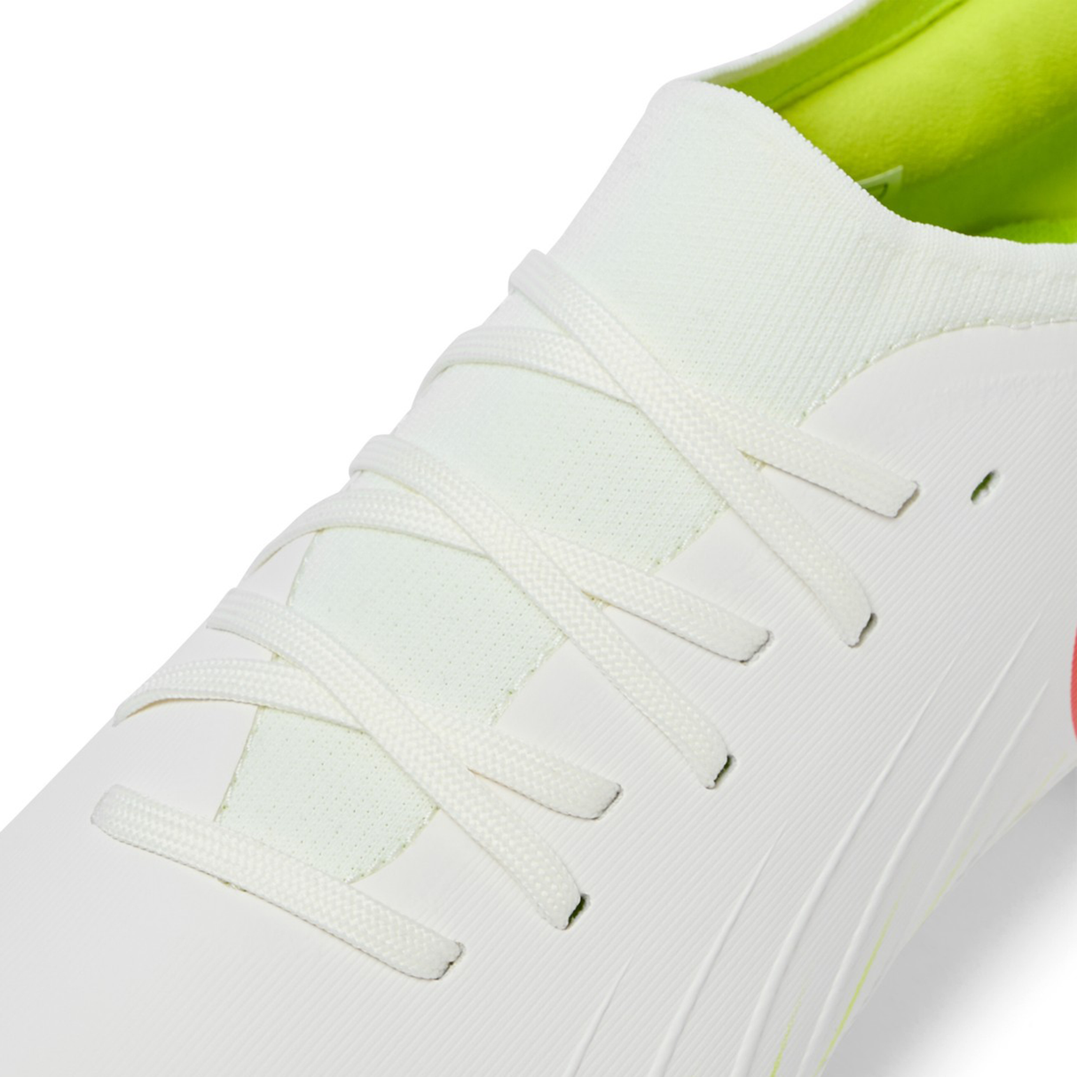 Close-up of the Canterbury Speed Falcon Pro FG in Snow White/Tangerine Tango, showcasing white laces and a light green inner lining.