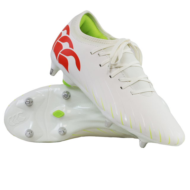 A pair of Canterbury Speed Falcon Team SG soccer cleats in Snow White/Tangerine Tango, featuring a red logo, neon green interior, and metal studs; one shoe stands upright while the other shows its sole.