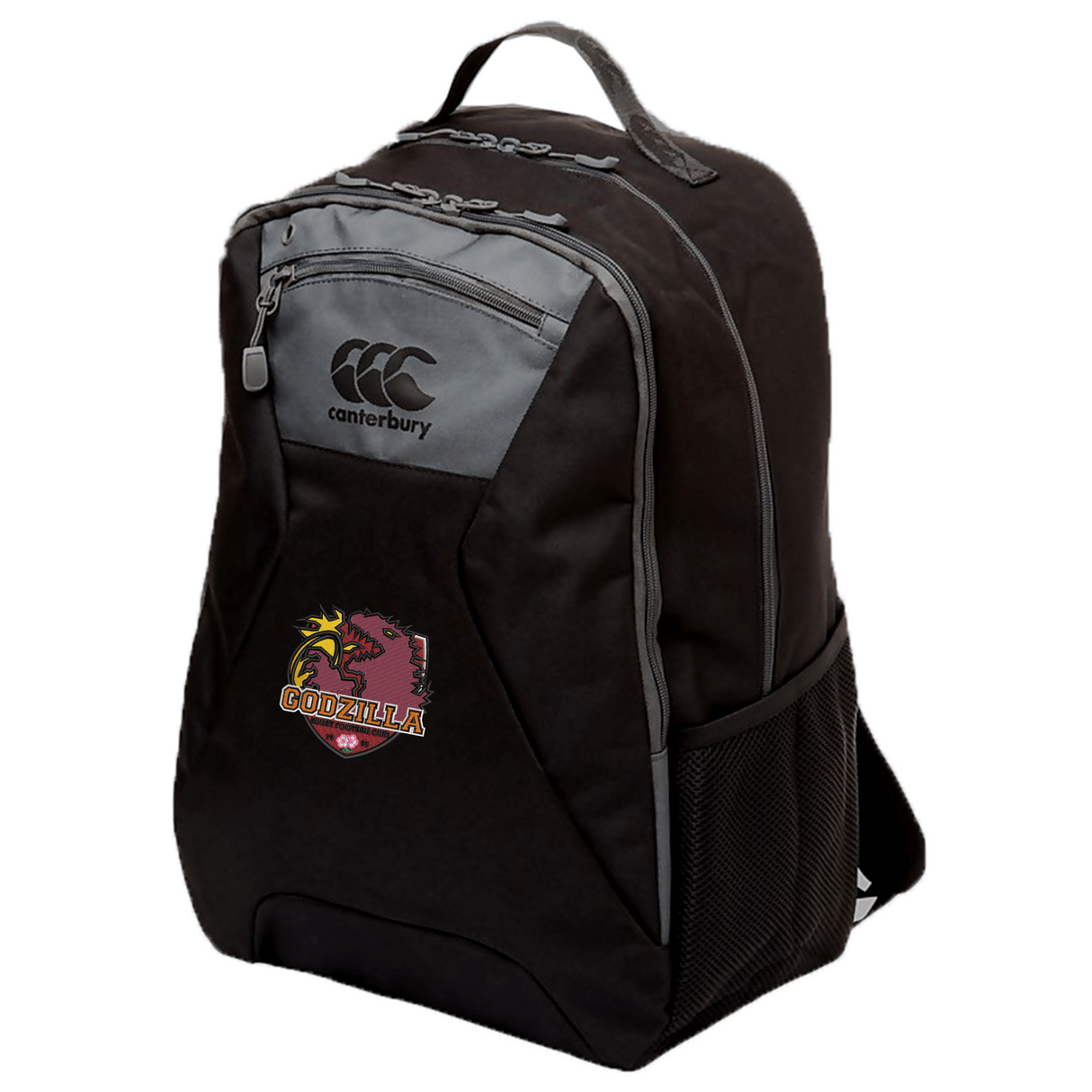 Introducing the Godzilla Rugby Football Club Medium Backpack by Canterbury, from EMB Canterbury. This black backpack features gray trim, a mesh side pocket, and a distinctive ‘Godzilla’ dragon patch with a football on the front pocket. With water repellent fabric and a padded laptop compartment, it’s ideal for everyday use while offering excellent protection for your gear.