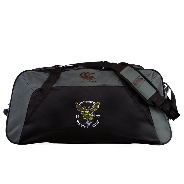The Hornets Rugby Club 1977 Holdall Duffle Bag by EMB Canterbury is a large black and gray sports bag featuring the “Hornets Rugby Club 1977” logo and a yellow hornet emblem on the front pocket. This water-repellent holdall includes an adjustable shoulder strap for comfortable carrying.