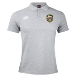 The RVA T.R.C. Waimak Polo by Canterbury, from EMB Canterbury, is a light gray men’s rugby shirt featuring the classic CCC Waimak Rugby Polo style. It has two logos on the chest: a white Canterbury logo on the right and a green and yellow RVA shield on the left, showcasing distinctive team detailing.