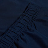 Close-up of dark blue fabric with gathered elastic stitching, reminiscent of a Canterbury logo design on the Women's Canterbury Open Hem Stadium Pant.
