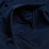 A detailed view of the Women's Canterbury Open Hem Stadium Pant showcases a navy blue fabric with an unzipped pocket, ideal for rugby training. The Canterbury logo adds a touch of authenticity and style to the design.