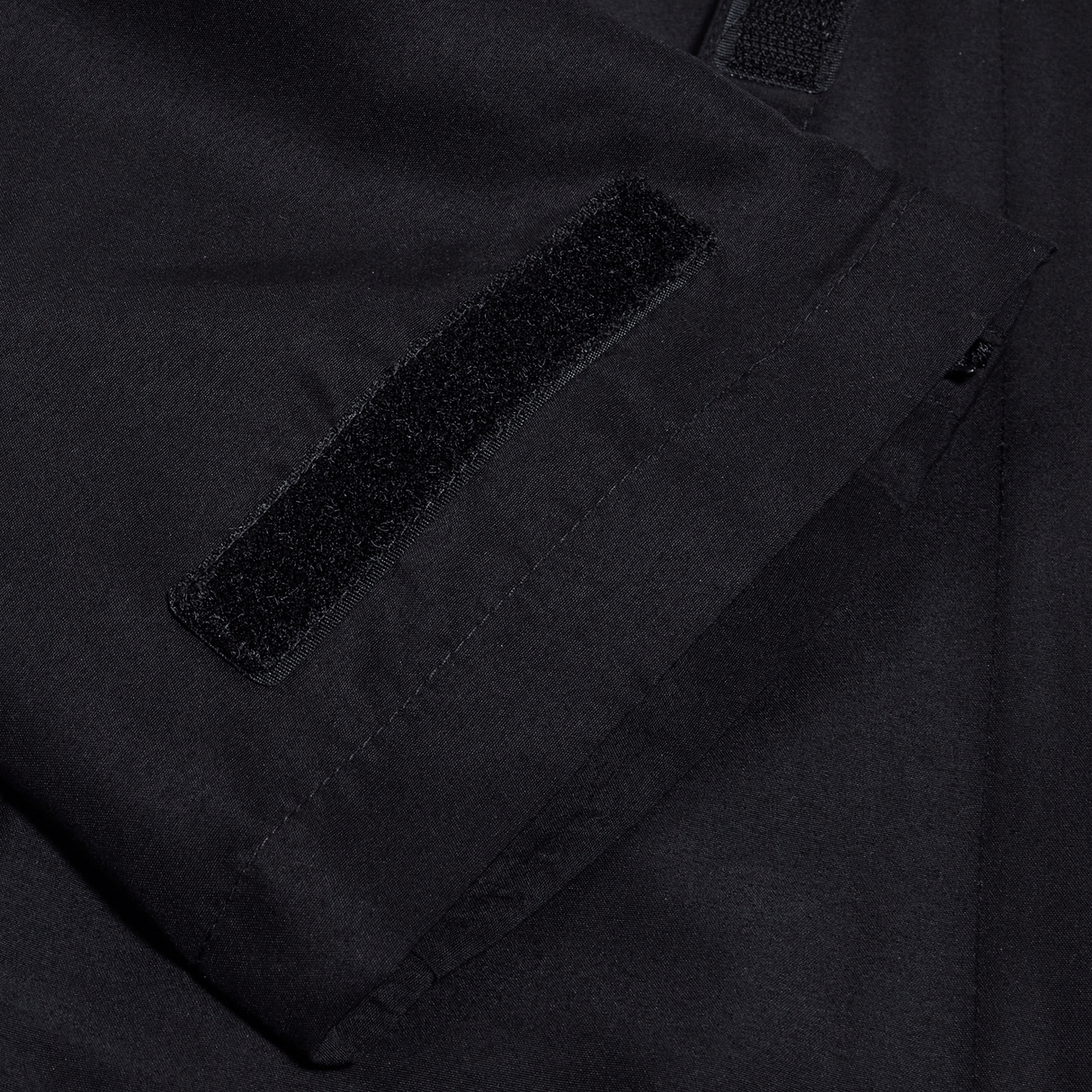 A close up of the pocket of a Canterbury black jacket.