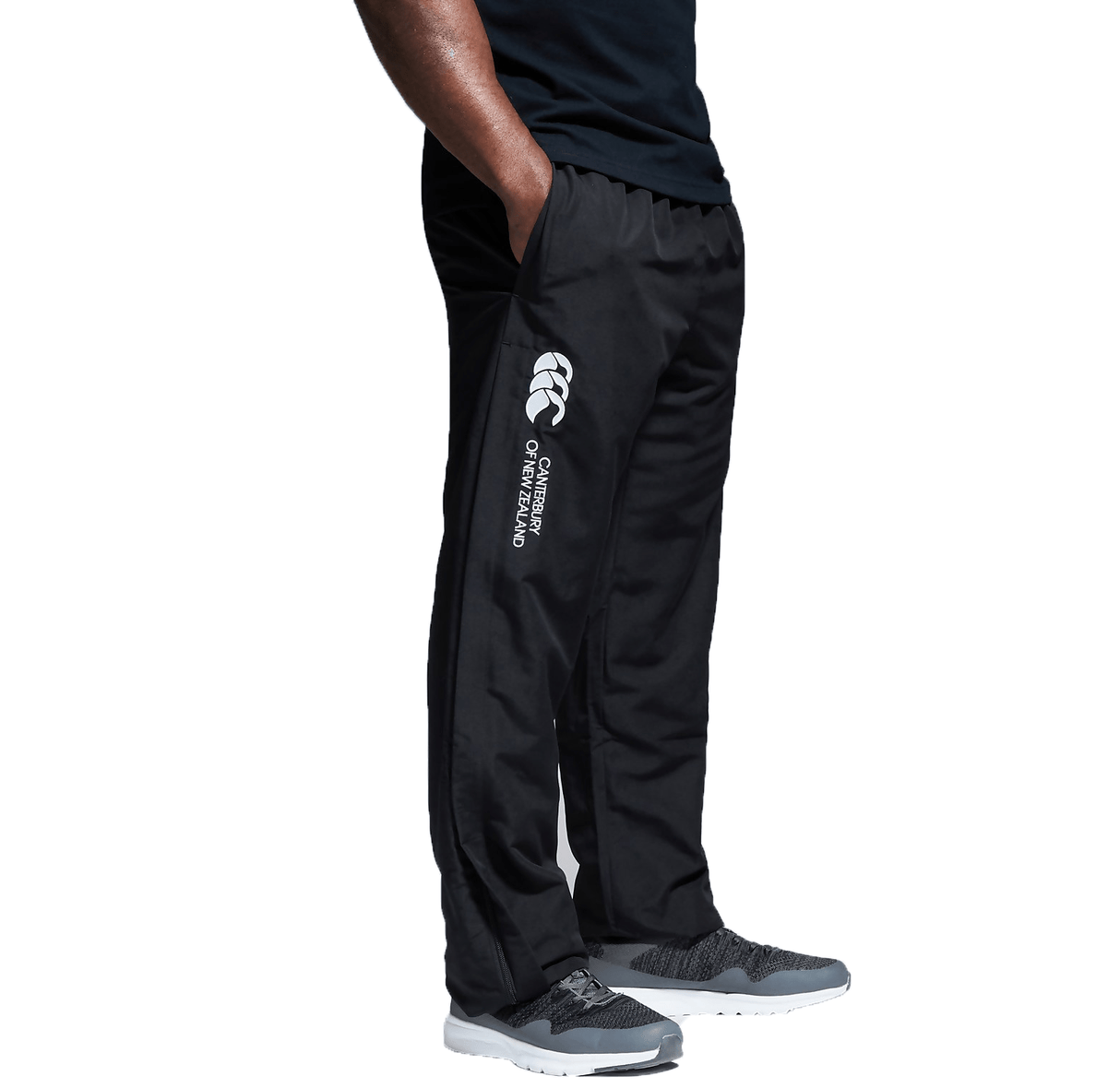 A man wearing Canterbury Open Hem Stadium Pant with white writing on the side.