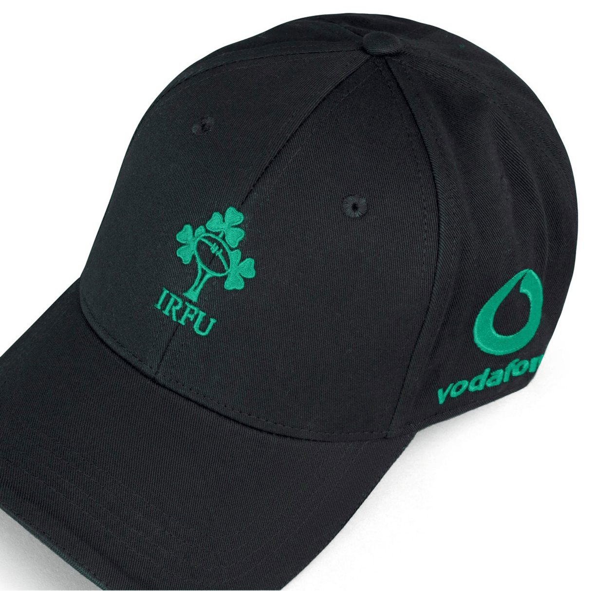 Introducing the Ireland 24 Drill Cap by Canterbury, a sleek black cotton cap adorned with the IRFU logo, showcasing a shamrock and the word "IRFU" in green embroidery on the front. The cap also features the Vodafone logo in green on its side and is fully adjustable for a comfortable fit.
