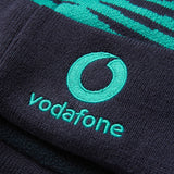 Close-up of a dark blue fabric with the Vodafone logo and text embroidered in teal, featured on the Ireland 26 Bobble Hat by Canterbury.