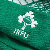 Close-up of a green knit fabric with the IRFU logo—featuring a rugby ball and shamrocks embroidered in white—perfect for an authentic Ireland 26 Bobble Hat by Canterbury.