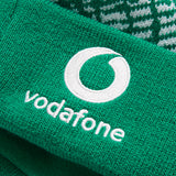 Close-up of green knit fabric with the white Vodafone logo and text embroidered on it, showcasing an authentic Ireland 26 Bobble Hat by Canterbury.