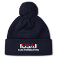 The USA Para Powerlifting Pom Pom Beanie by EMB Canterbury is a navy blue knit beanie with a pom-pom, featuring "USA PARA POWERLIFTING" and a barbell on the front cuff, inspired by classic Rugby style.