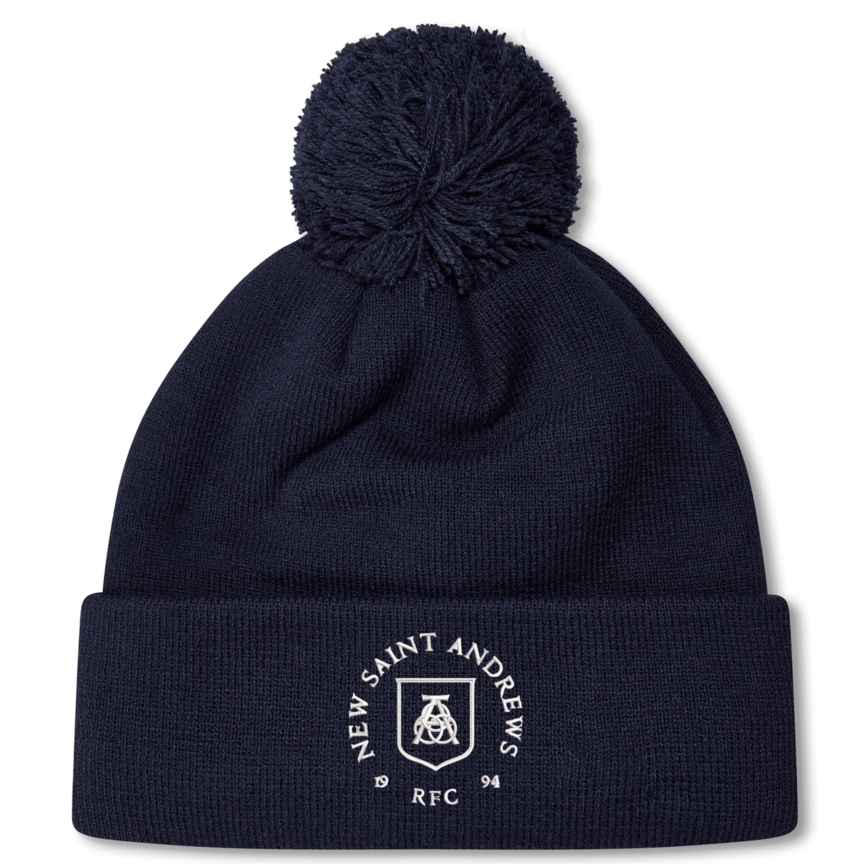 Introducing the New Saint Andrews College Pom Pom Beanie by Canterbury: a navy blue knit beanie with a playful pom-pom on top, featuring the white New Saint Andrews RFC logo embroidered on the cuff. Brought to you by EMB Canterbury.